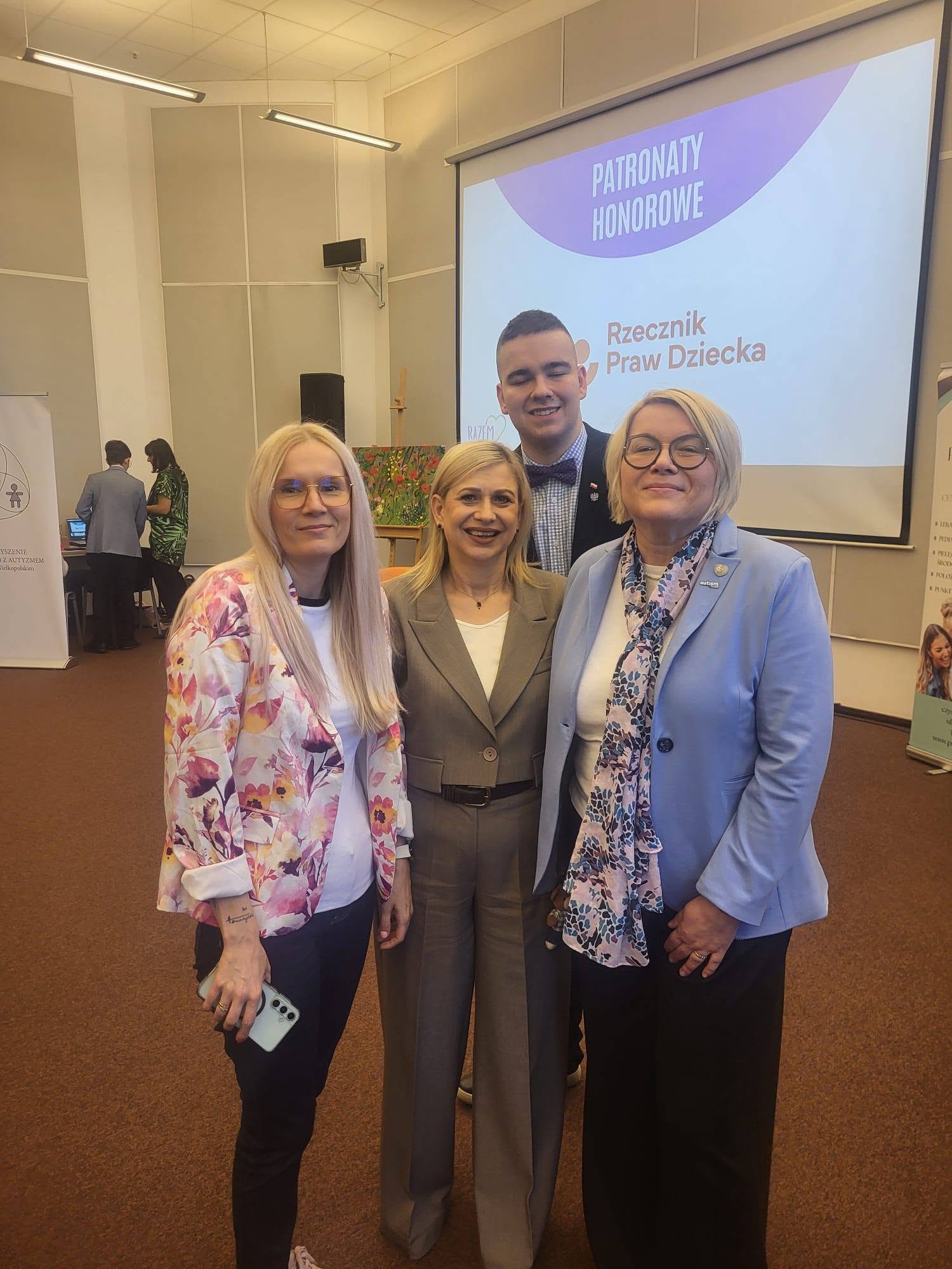 Uczestnicy konferencji przy ekranie z informacją o patronacie